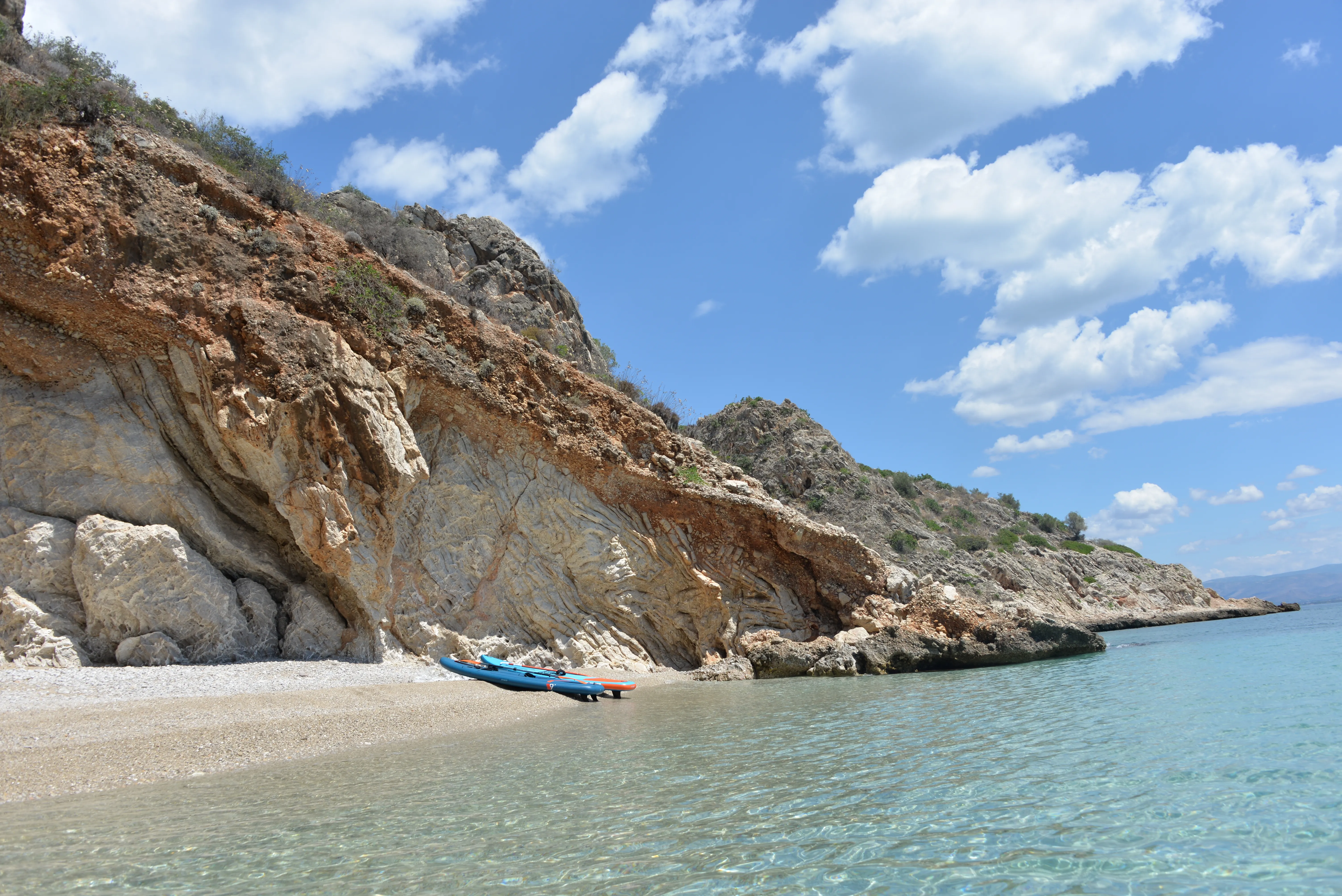 Σανίδα paddleboard τραβηγμένη στην ακτή ενός όρμου με ρηχά καθαρά νερά