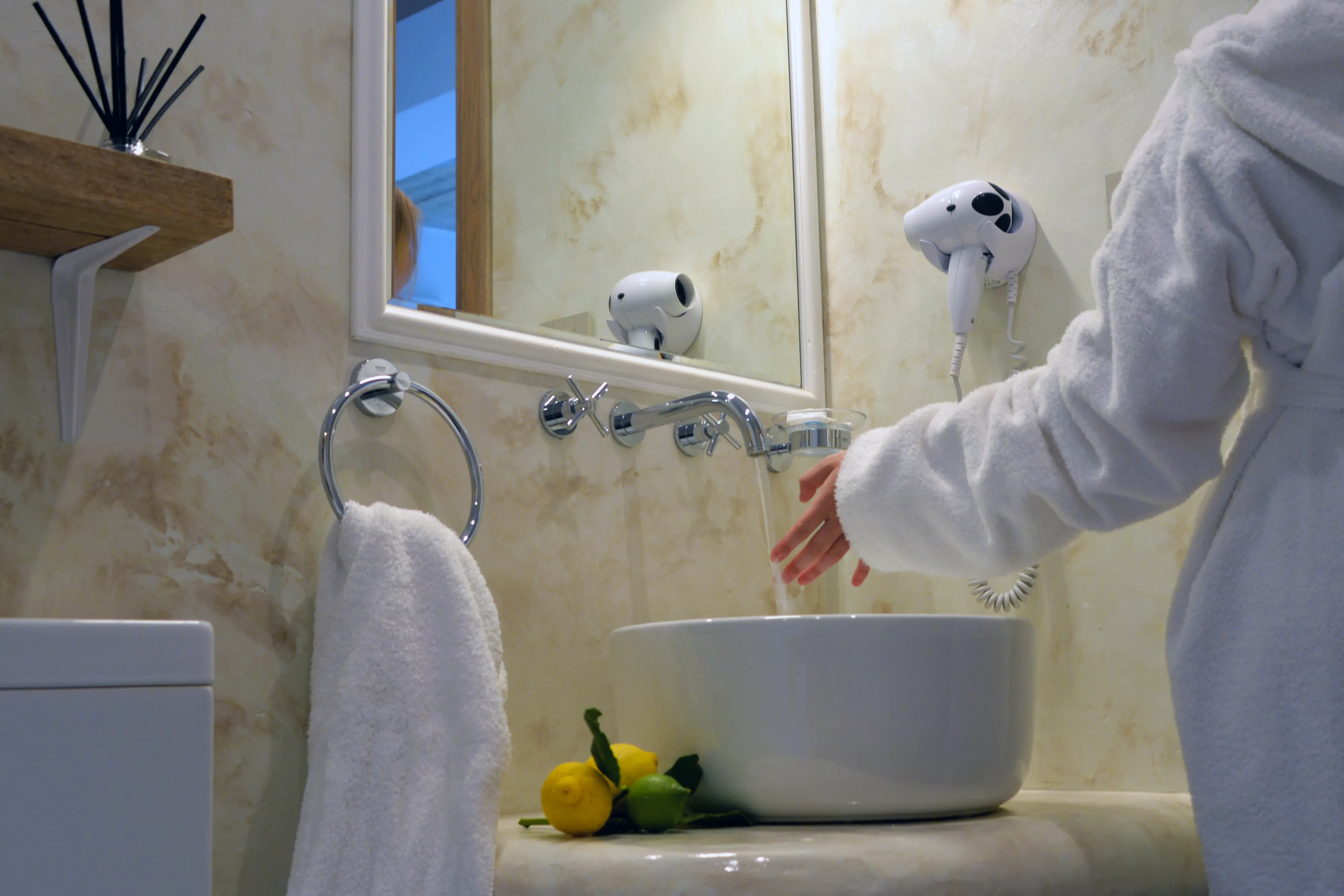Waschbecken mit Zitronen und Spiegel im Bad von Notos