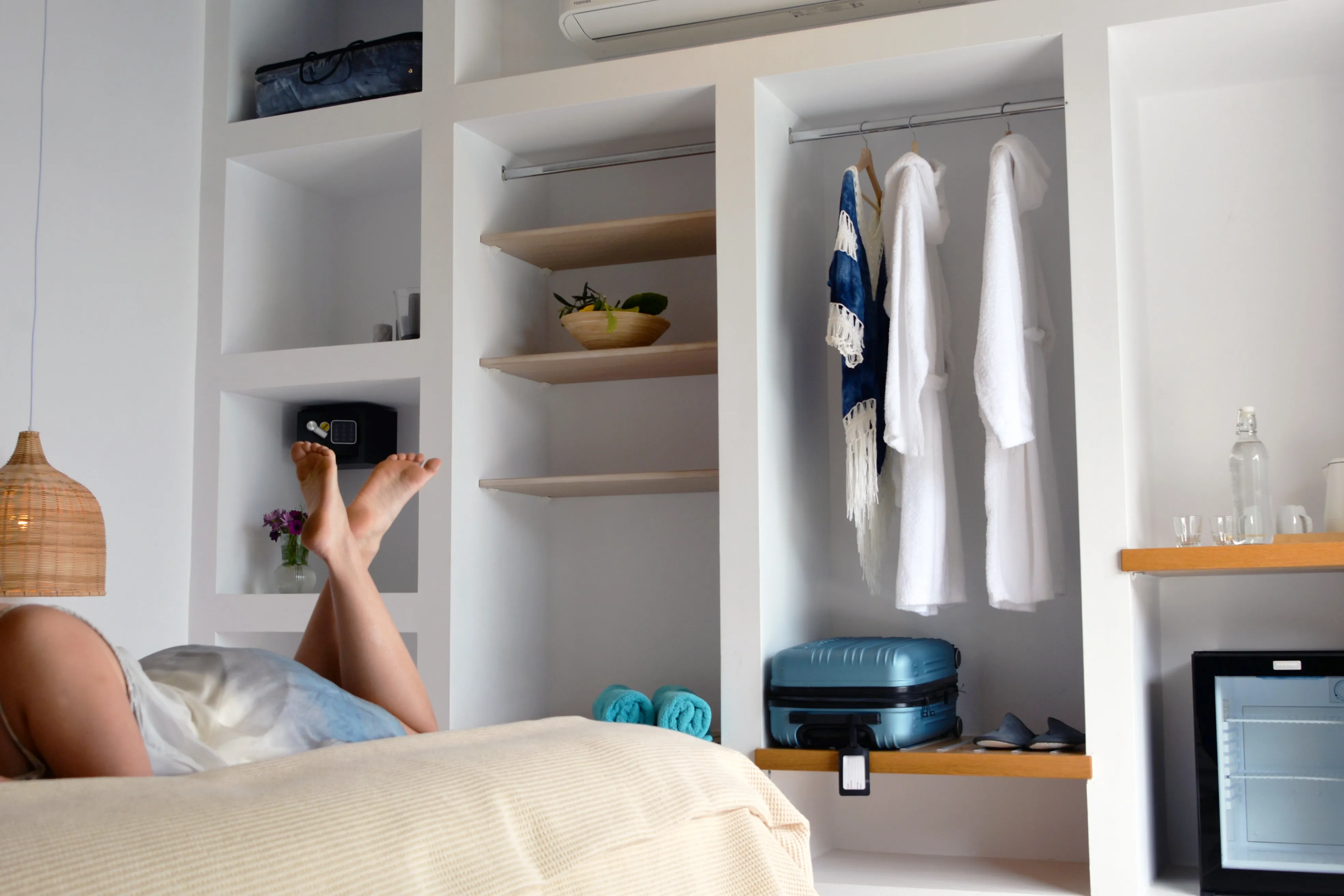 Gast ruht auf dem Bett neben offenen Schrankregalen