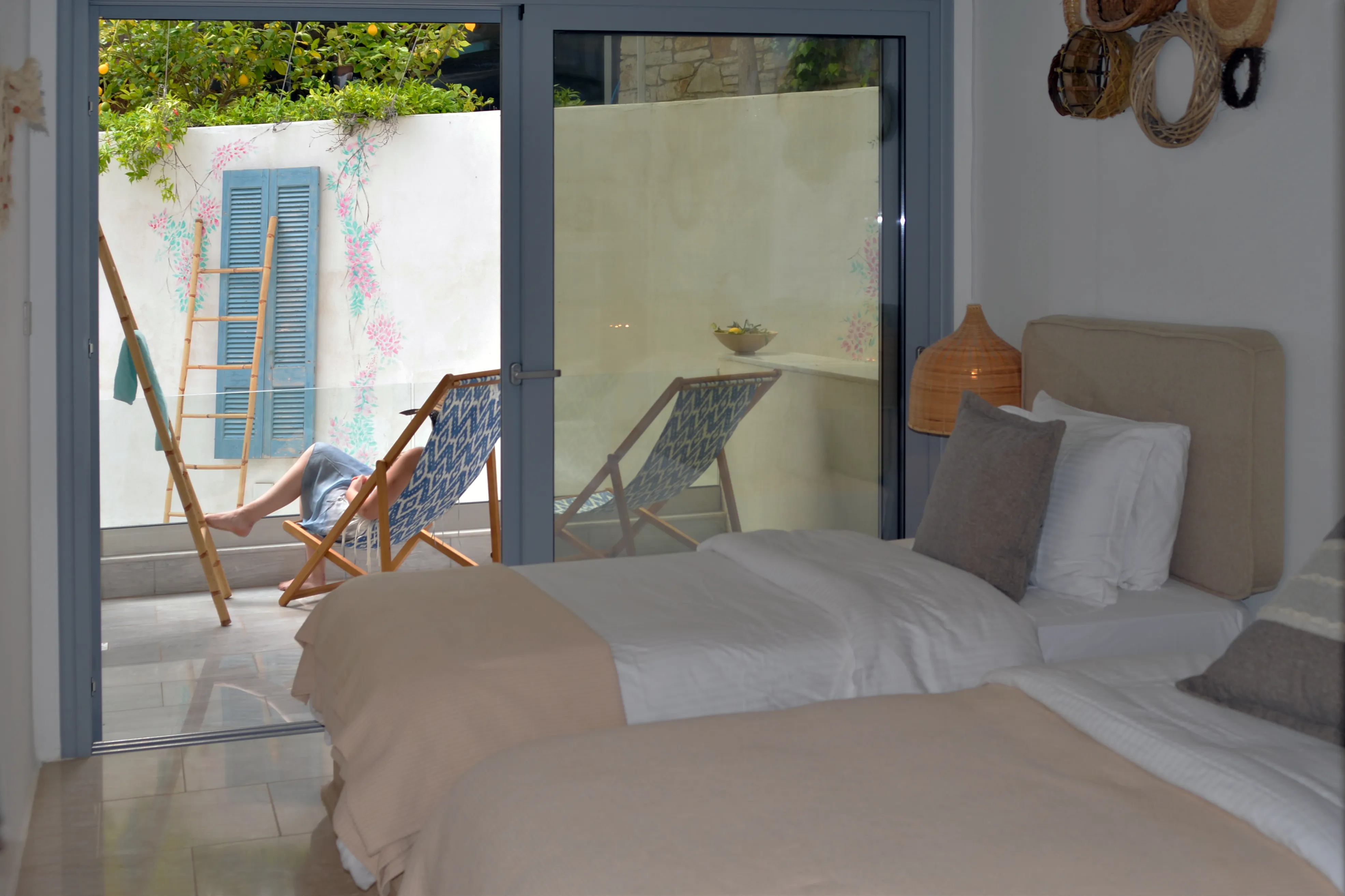 Zweites Schlafzimmer von Zephyros mit Einzelbetten und Liegestühlen auf dem Balkon